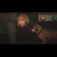 a young man is petting a dog on the nose in a dark room with an orange ball behind him