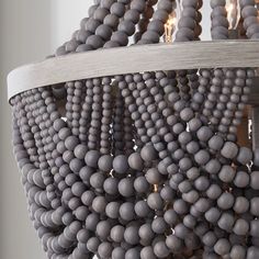 a chandelier made out of balls hanging from it's sides with candles in the middle