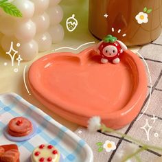 there is a heart shaped tray with cupcakes and cookies on the table next to it