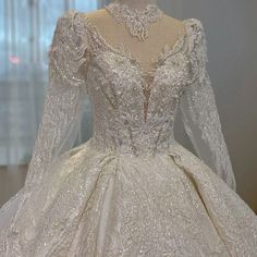 a white wedding dress on display in front of a window