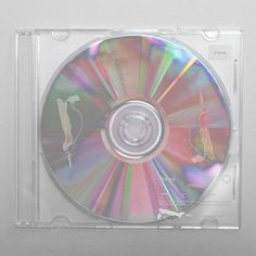 a cd that is sitting on top of a glass case with the disc in it's center