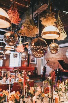 the tables are set with candles, flowers and disco ball lights hanging from the ceiling