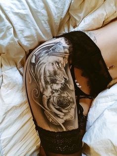 a woman laying on top of a bed next to a tattoo