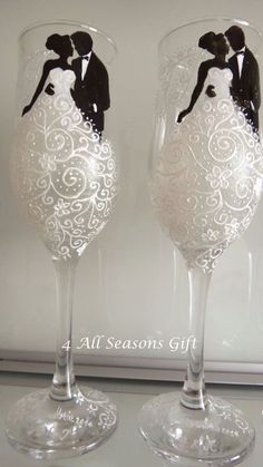 two wine glasses decorated with an image of a bride and groom on the top one