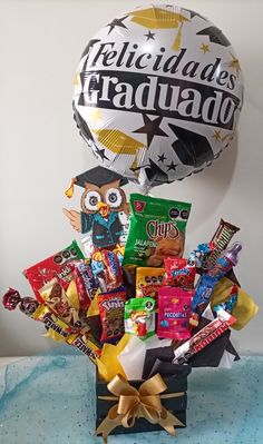 a basket filled with candy and balloons on top of a table