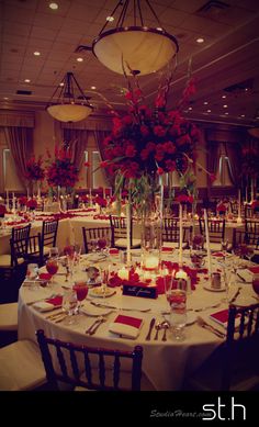 a dining room set up for a formal function with candles and flowers on the tables