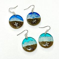 These realistic beach earrings and pendants are made with layers of resin, bright colorful inks and real sand with a 3D silver turtle crawling in the sand. These earrings are 1" diameter. The pendant is 1" diameter on a 16" silver plated chain. I make my own molds and each set is handmade so you won't find these anywhere else.  4 colors available  *Protect your resin jewelry. Prolonged exposure to direct sunlight can result in color fading.   These are made to order and may be slightly different than the ones pictured. It takes 3-5 days to make these. Please keep that in mind when requesting faster shipping. The shipping estimate does not begin until the item is created.  Sometimes I have these in stock and can ship the next day. If you are in a hurry, please contact me to check on availab Resin Round Pendant Jewelry For Beach, Ocean-inspired Earrings For Beach, Sea Turtle Earrings, Blue Resin Earrings For Beach, Blue Shell-shaped Earrings For Beach, Tropical Jewelry, Turtle Beach, Beach Earrings, Turtle Earrings