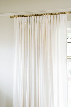 a white curtain hanging in front of a window