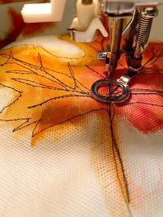 a close up of a sewing machine with leaves on it