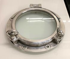 a close up of a metal porthole on a white counter top with no one around it