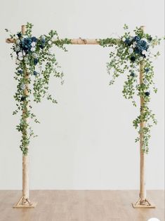 an arch made out of branches with flowers and greenery