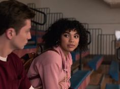 a woman sitting next to a man in a pink shirt