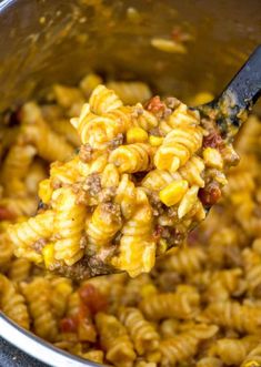 a spoon full of macaroni and cheese with meat