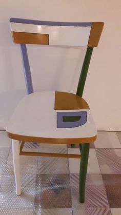 a wooden chair with a hole in the back and seat painted white, brown, and blue