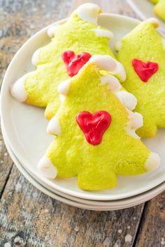 christmas tree cookies on a white plate with red hearts