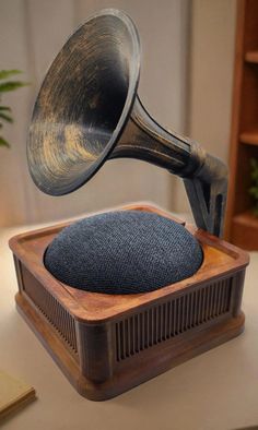 an old fashioned speaker is sitting on a desk with a wooden box and metal object in the foreground