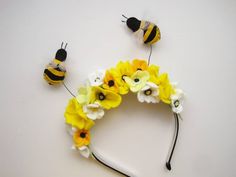 some flowers and bees are laying on the table next to each other, one is wearing a flower crown