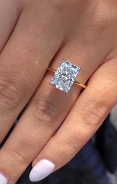 a woman's hand with a ring on it and a diamond in the middle