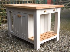 a white and grey kitchen island sitting on top of gravel