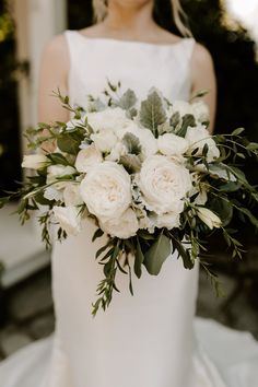 a bride holding a bouquet of white flowers