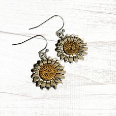 Stunning silver and gold tone sunflower drop earrings will go with everything and any occassion. Dimensional charms feature antique silver flower petals with a lovely gold tone center. Very pretty and unusual, these artisan handmade earrings will go with all your silver or gold jewelry and look great when worn alone. Ear wires are hypoallergenic, nickel and lead free. Choose your ear wire style at checkout. Free gift packaging included. Earrings are carded and in an organza bag. Link back to my shop: https://www.etsy.com/shop/JezaJewelry Mixed Metal Sunflower Charm Earrings - Gold and Silver Drops - Handmade Jewelry Gift for Her Sunflower Design Dangle Earrings For Gift, Sunflower Design Dangle Earrings As Gift, Silver Flower-shaped Brass Earrings, Vintage Adjustable Sunflower Design Jewelry, Anniversary Gold Jewelry With Sunflower Design, Vintage Gold Earrings With Flower Charm, Vintage Gold Jewelry With Sunflower Design, Silver Jewelry With Sunflower Design, Adjustable Sunflower Design Dangle Jewelry