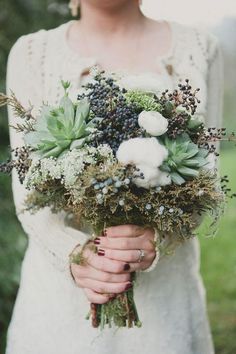 a woman holding a bouquet of flowers in her hands