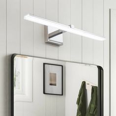 a bathroom with a mirror, towel rack and pictures on the wall above it is shown