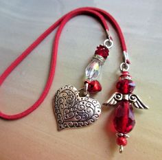 a red necklace with an angel charm attached to it