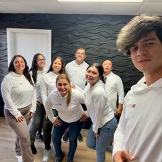 a group of people in white shirts posing for a photo