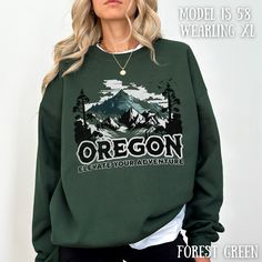 "Whether you're looking for a gift for her or a gift for him, this versatile, oversized crewneck sweatshirt is the ideal choice for anyone seeking the perfect fusion of fashion and function. This unisex pullover is not just a clothing item; it's a statement piece that proudly showcases the picturesque allure of Oregon's majestic mountains.  Whether you're hiking through Oregon's untamed wilderness or embarking on a cross-country road trip, this versatile Oregon sweatshirt is your ideal companion Fall Hiking Sweatshirt Crew Neck, Fall Hiking Crew Neck Sweatshirt, Fall Crew Neck Sweatshirt For Adventure, Fall Crew Neck Sweatshirt For Hiking, Winter Adventure Long Sleeve Sweatshirt, Long Sleeve T-shirt For Fall Adventure, Casual Crew Neck Sweatshirt For Adventure, Fall Hiking Sweatshirt With Letter Print, Winter Adventure Crew Neck Sweatshirt