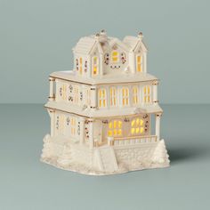 a small white house with lights on it