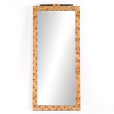 a wooden mirror hanging on the wall next to a white wall with a cork frame