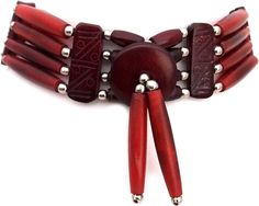 a close up of a red bracelet with metal beads and two pairs of scissors on it