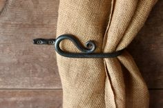 an iron hook on the side of a burlocked curtain