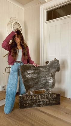 a woman standing next to a wooden sign with the word homespun written on it