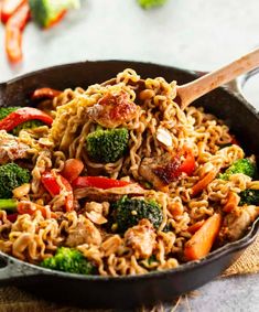 a skillet filled with noodles, broccoli and meat