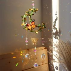 a wind chime hanging from the side of a window with butterflies and leaves on it