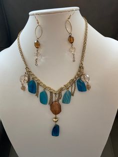 "Blue, brown, gold themed chain and bead necklace and earrings made from vintage materials.  Earrings have French hooks and necklace had lobster claw clasp.  Kept in a smoke free environment. Necklace measures 25\" long.  Earrings measure 3\"." Bohemian Gold Chain Necklace, Bohemian Metal Jewelry With Gold Chain, Bohemian Gold Chain Metal Jewelry, Bohemian Metal Gold Chain Jewelry, Bohemian Brown Jewelry With Lobster Clasp, Brown Czech Glass Jewelry With Beaded Chain, Brown Czech Glass Beaded Chain Jewelry, Vintage Brown Dangle Jewelry, Bohemian Gold Chain Jewelry