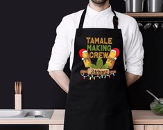 a man wearing an apron with the words tamale making crew printed on it in front of him