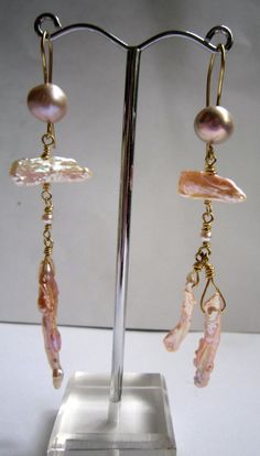 Very much in vogue sugar pink pearl earrings suitable for a current pastel palette. Playfully arranged with four shapes of pink pearls, baroque, flat, round and stick. Pearls are offset in a warm glow of yellow 18ct gold. This is a one off pair of gorgeous pink earrings inspired by jewellery from the ancient world which was always aimed at individuals and remains timeless.They are individually designed and handmade in the jewellery district of London, Hatton Garden by Kochi Okada – see more abou Elegant Pink Dangle Linear Earrings, Elegant Pink Linear Drop Earrings, Pink Pearl Charm Drop Earrings, Formal Pink Baroque Pearl Jewelry, Pink Pearl Earrings With Pearl Charm, Pink Drop Pearl Earrings For Formal Occasions, Elegant Pink Linear Earrings As Gift, Pink Pearl Charm Earrings For Wedding, Pink Pearl Charm Wedding Earrings