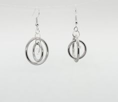 These playful and flirty spinner earrings defy gravity with their steel hoops and crystal bead accent. The inner part spins for a cool and distinctive effect. The metal is hypoallergenic stainless steel that won't tarnish easily. The largest circle measures about an inch and a half in diameter. They're lightweight and perfect for fidgeting, just like me! Modern Stainless Steel Hoop Jewelry, Modern Twist Round Metal Earrings, Modern Stainless Steel Hoop Earrings For Pierced Ears, Modern Stainless Steel Pierced Hoop Earrings, Modern Internally Threaded Adjustable Earrings, Hypoallergenic Round Stainless Steel Earrings, Hypoallergenic Stainless Steel Round Earrings, Hypoallergenic Spiral Metal Earrings, Nickel-free Round Earrings With A Modern Twist