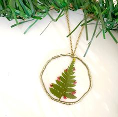 Embrace the holiday spirit with this cute Christmas Tree Necklace - a festive piece that captures the essence of the season! Crafted with genuine pressed flowers, each delicate detail is lovingly encased in high-quality UV resin, ensuring a timeless and durable finish. Whether it's a gift for a cherished someone or a treat for yourself, this necklace radiates holiday joy!  Details: - Necklace Material: 18k gold-plated stainless steel, combining elegance with durability. - Necklace Length: 18 inches, adorned with a dazzling Christmas tree pendant. - Bezel Material: gold-plated alloy  - Please note that the uniqueness of each flower, just like nature itself, means that the finished product may exhibit slight variations.  To preserve the magic of your Christmas Tree Necklace: - Gently wipe wi Nature-inspired Gold Necklace With Pressed Flowers, Nature-inspired Necklaces With Pressed Flowers For Gifts, Nature-inspired Leaf-shaped Jewelry With Pressed Flowers, Nature-inspired Flower Necklace With Pressed Flowers, Nature-inspired Green Necklace With Pressed Flowers, Christmas Tree Necklace, Christmas Tree Beads, Christmas Tree Shop, Christmas Necklace