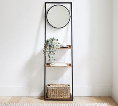 a shelf with a mirror on it next to a basket and a potted plant