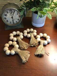 some tassels are sitting on a table next to a clock and potted plant