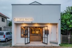 the front entrance to a coffee roaster with its lights on, and an open door