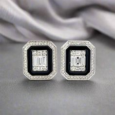 These diamond and black enamel earrings feature a captivating blend of illusion set natural diamonds and bold black enamel. The result is striking and eye-catching. With this unique design, these earrings will elevate any outfit and add a touch of elegance to your look. Matching ring available. Metal Type : 18K White Gold Weight : 6.5 grams Diamond Shape : Mixed, round and baguette Diamond Clarity : VS2-SI2 Diamond Color : H-I Diamond Weight : 1.29 ctw Each Earring : Approximately 15 mm x 11 mm Matching Ring, Matching Rings, Classic Jewelry, Enamel Earrings, Bold Black, Diamond Color, Baguette Diamond, Diamond Shape, Black Enamel