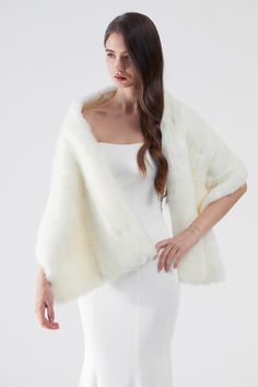 a woman is wearing a white dress and a fur stole over her shoulders, with one hand on her hip