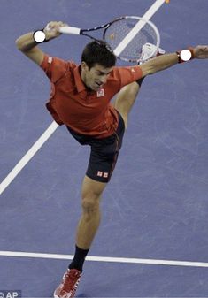 a man swinging a tennis racquet on top of a tennis court