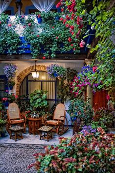 an outdoor patio with potted plants and chairs