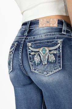 -Mid-rise, medium wash bootcut denim-Embroidered longhorn with Aztec print on back pockets-White, beige and turquoise stitching-Silver sequins and turquoise bead rivet-Rhinestone rivets-Light Pink brand patch with white Aztec embroidery-Fading-Front Rise: 9", Back Rise: 14"-Inseam: 34"-73% Cotton, 24% Viscose, 3% Elastane-Gentle machine wash with like colors in cold water, Tumble dry low Model is wearing size: 25Model Measurements: Height: 5'9" Bust: 34" Waist: 24" Hips: 34" Style No. M9187B-M893 Boot Cut Jeans Cowgirl, Pure Western Jeans, Cow Girl Jeans, Embroidered Bootcut Jeans, Gem Jeans, Longhorn Design, Cowgirl Pants, Jean Embroidery, Cute Western Outfits